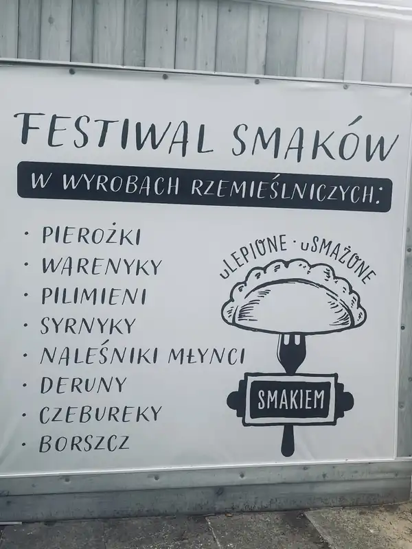Baner Festiwal smaków z listą dań i logo z pierogiem na widelcu
